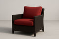 Sillón de resina trenzada con cojines rojos