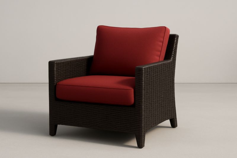 Sillón de resina trenzada con cojines rojos