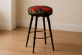 Taburete alto redondo de tela con estampado floral, metal negro y dorado